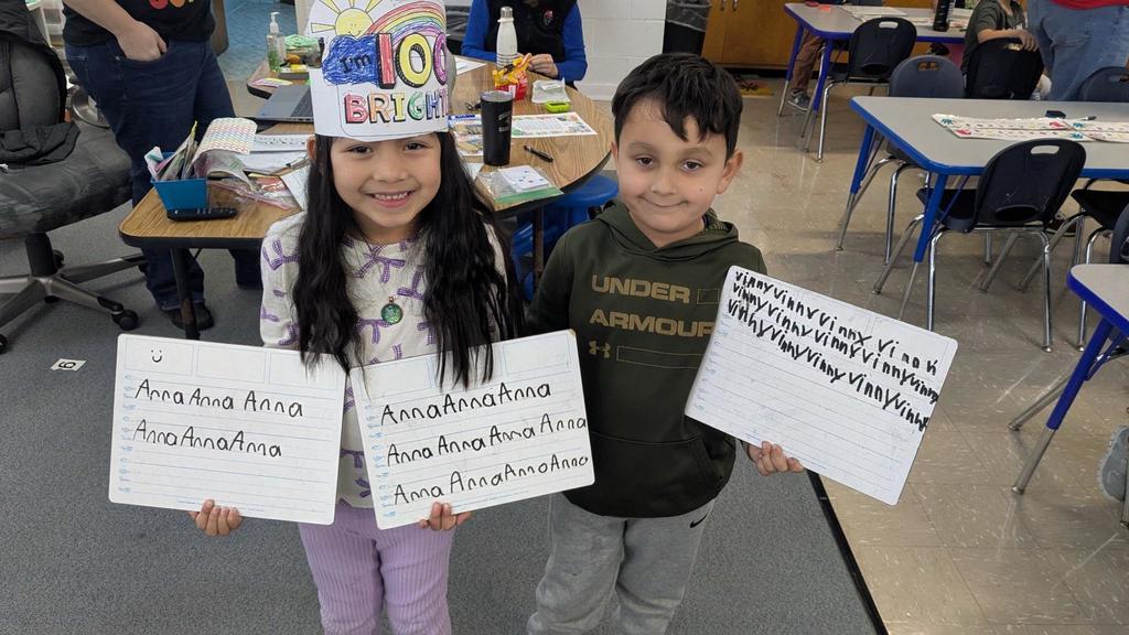 Students holding up signs with their names on them.