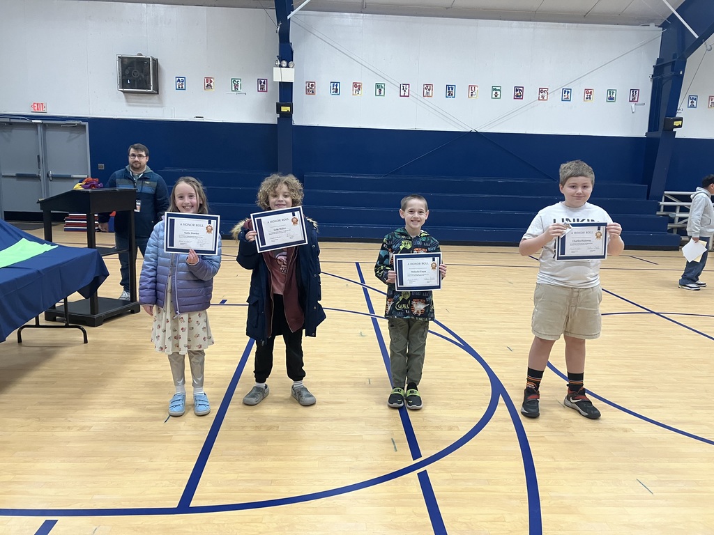 Students stand holding their certificates.