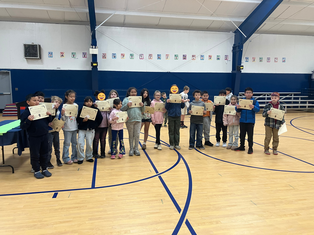 Students stand holding their certificates.