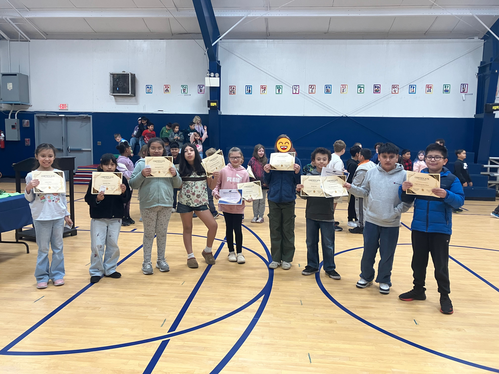 Students stand holding their certificates.