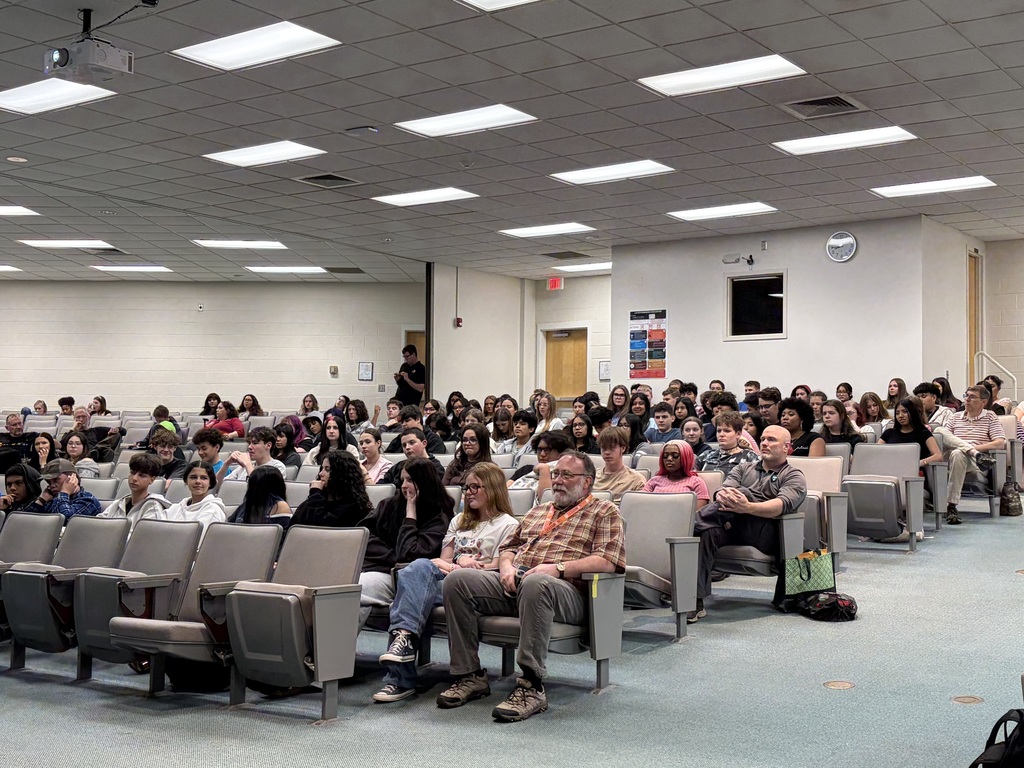 students are gathered in an auditorium for an assembly
