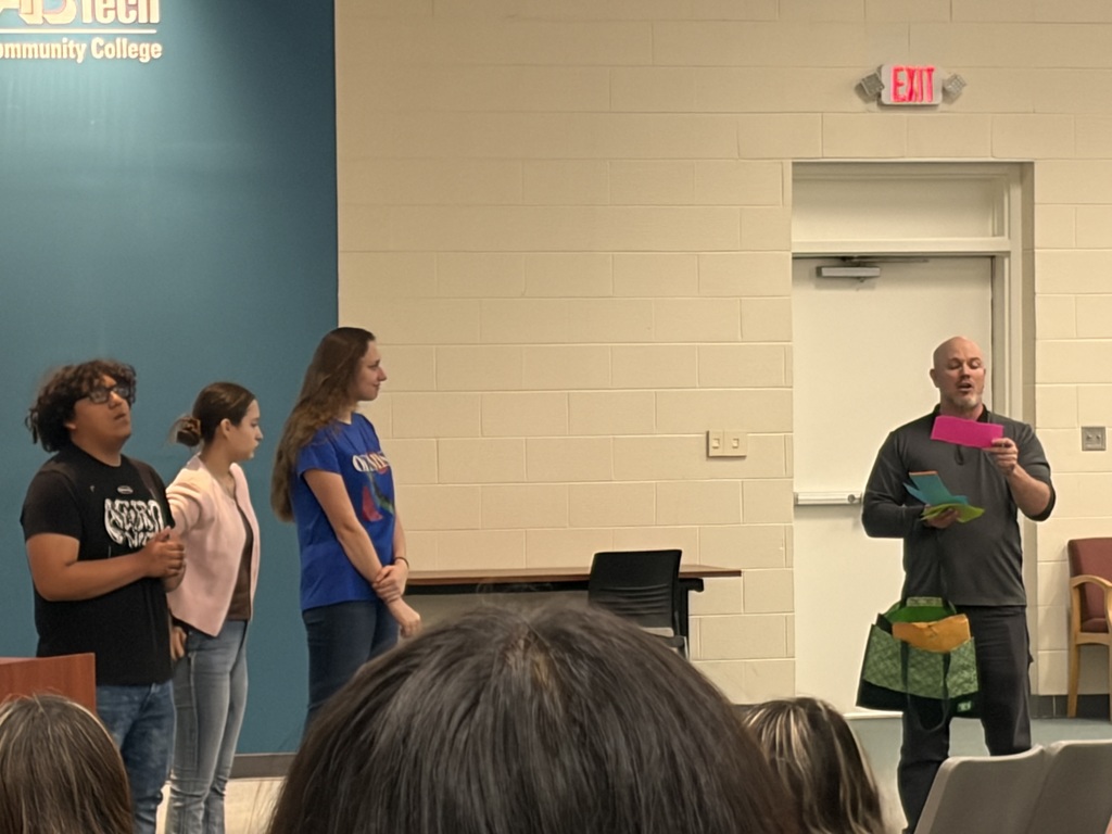 a teacher reads aloud names of two students who are recognized for graduate outcomes 