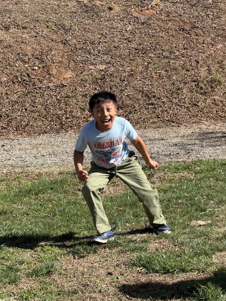 Student smiles in field.