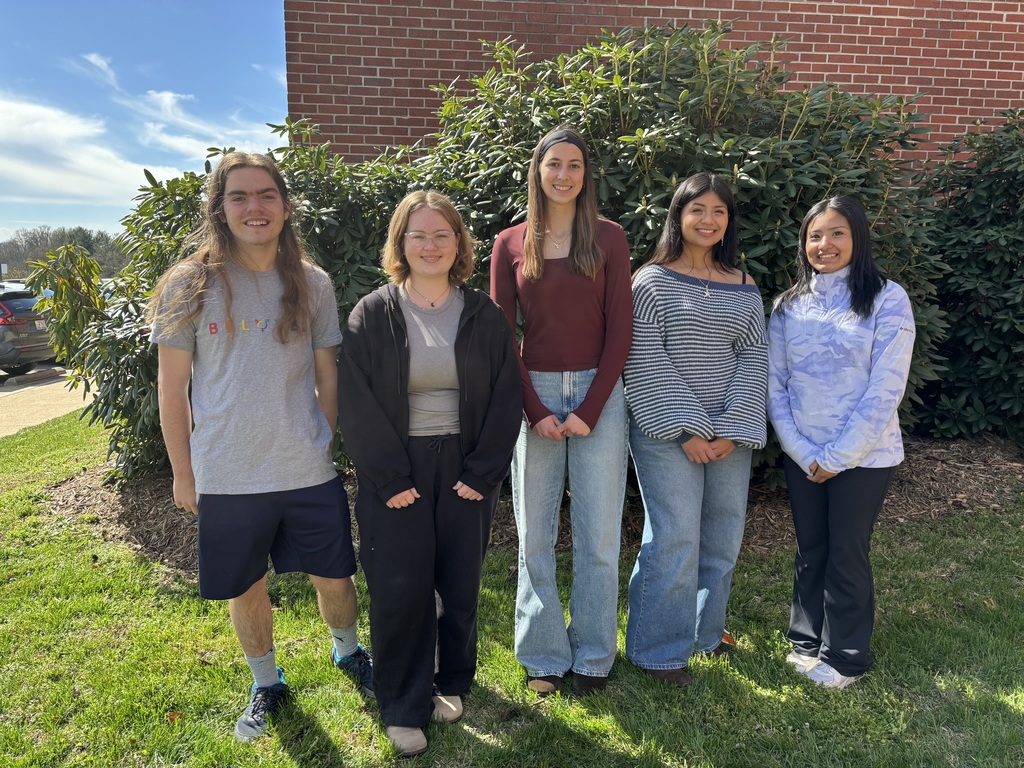 5 NDA Students who were chosen for Governor's School standing in front of the school building with greenery behind them