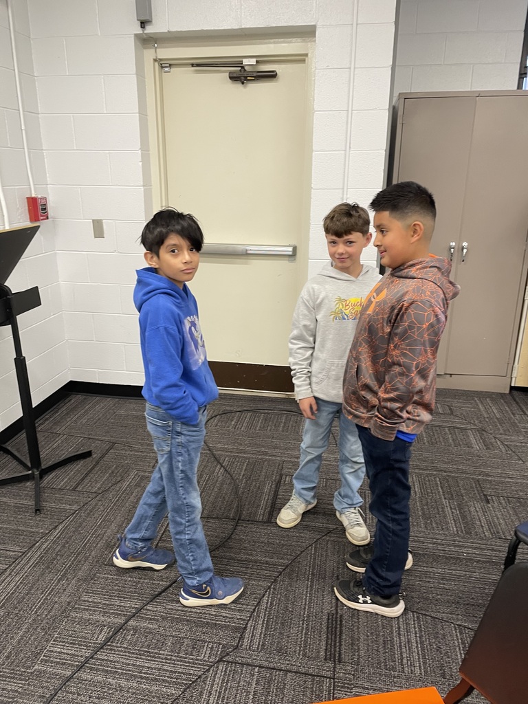 Three students stand together.