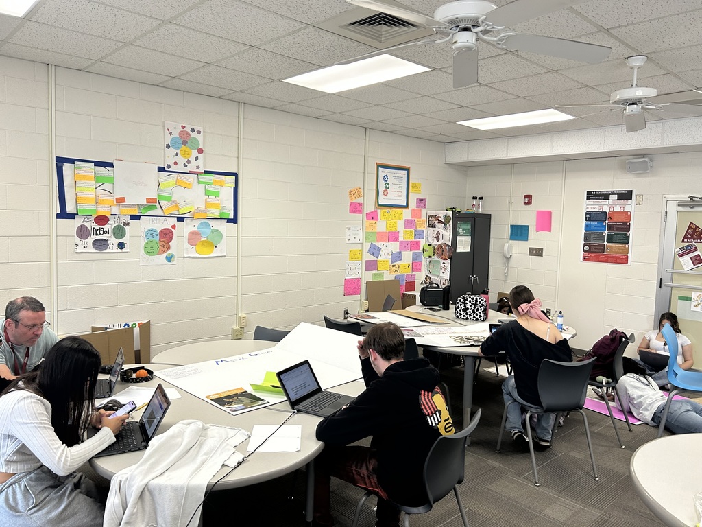 a group of students sitting at tables and working on a project