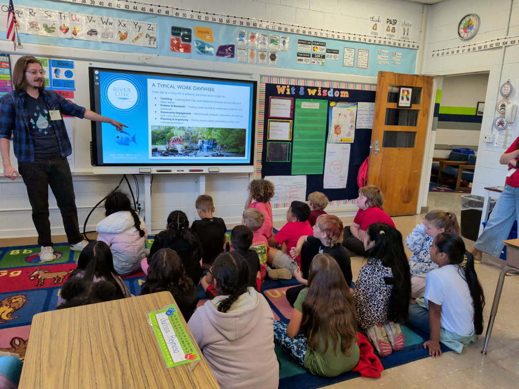 Presenter points to board as students look on. 