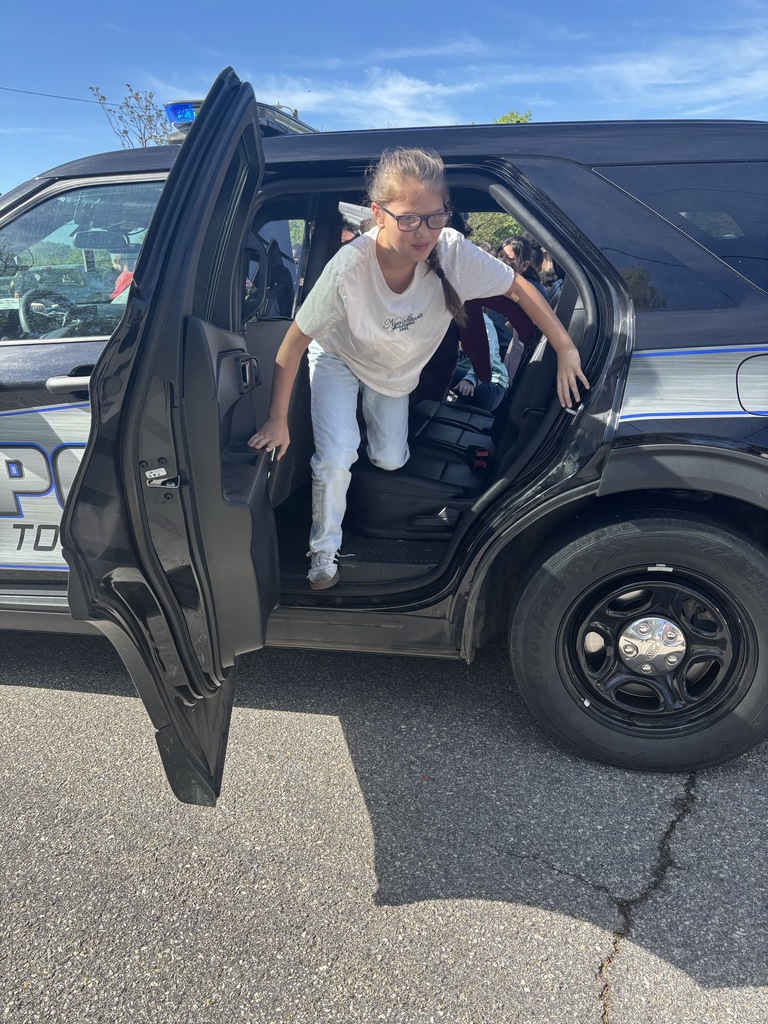 Student climbing out of a Woodfin Police Department Vehicle. 