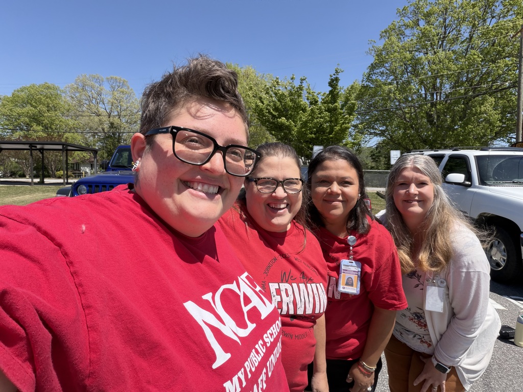 Four staff stand together smiling. 