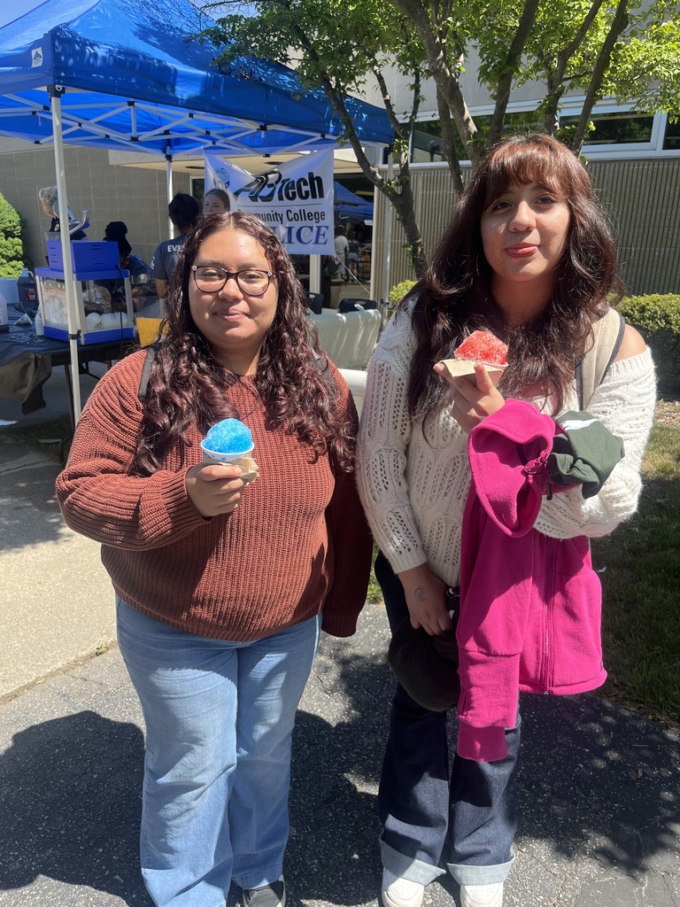 two students standing outside holding snow cones 
