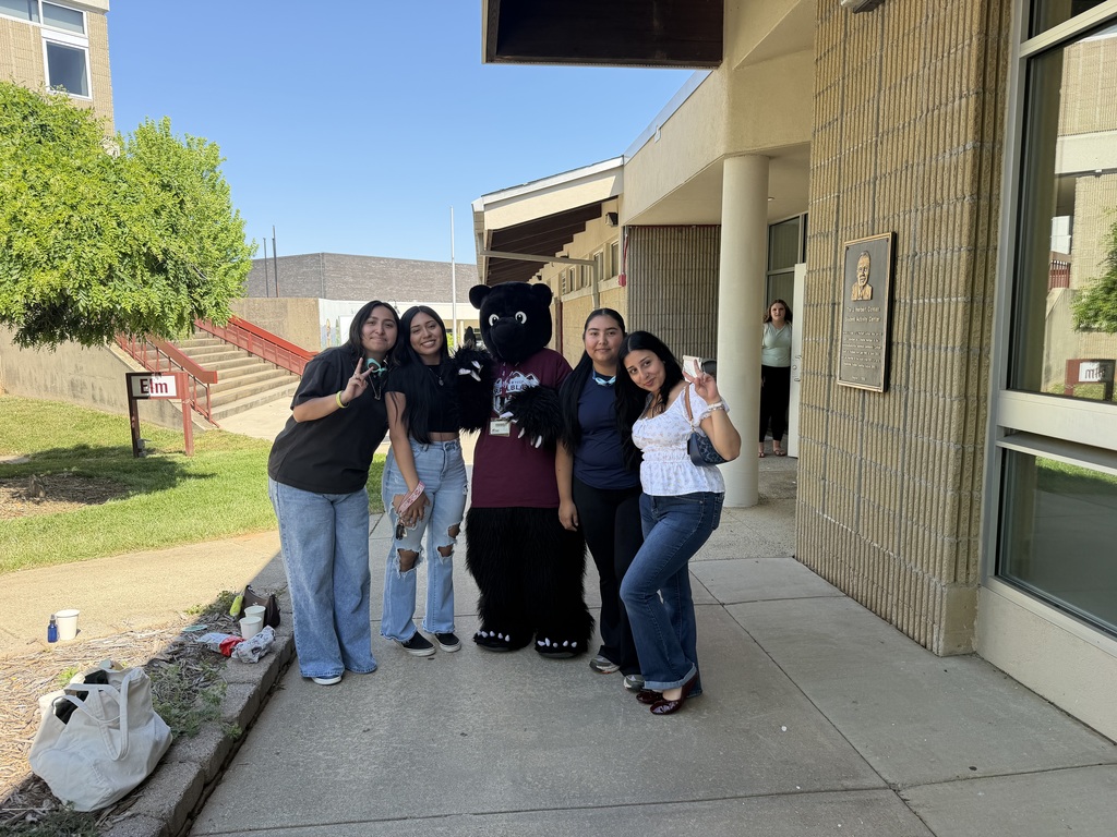 four students standing outside with the AB Tech bear mascot 