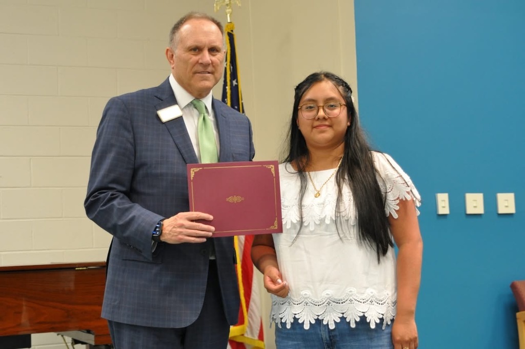adult and student standing side by side holding an award 