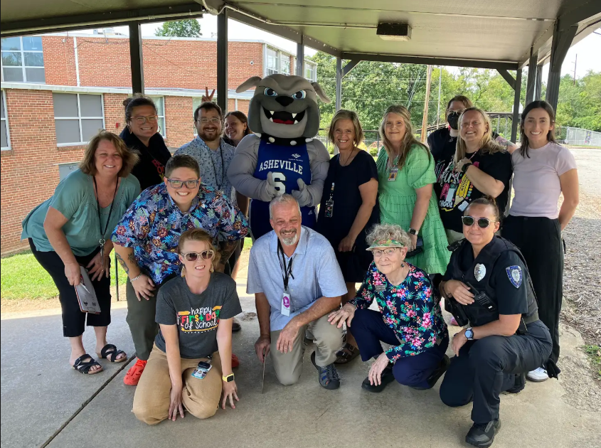 All staff standing together and smiling.