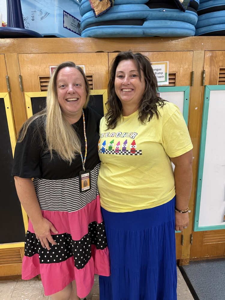 Teachers stand smiling together.