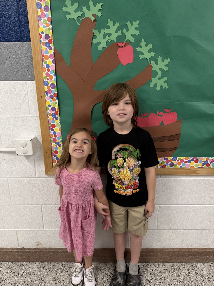 Students stand smiling together .