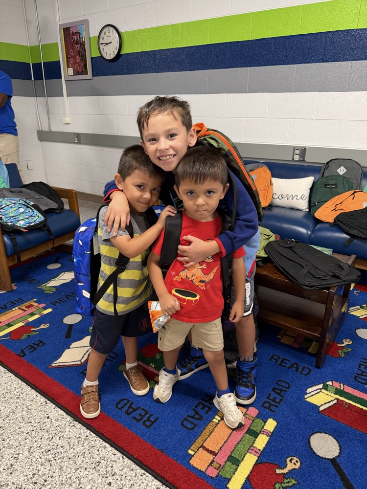 Three students stand together for photo.