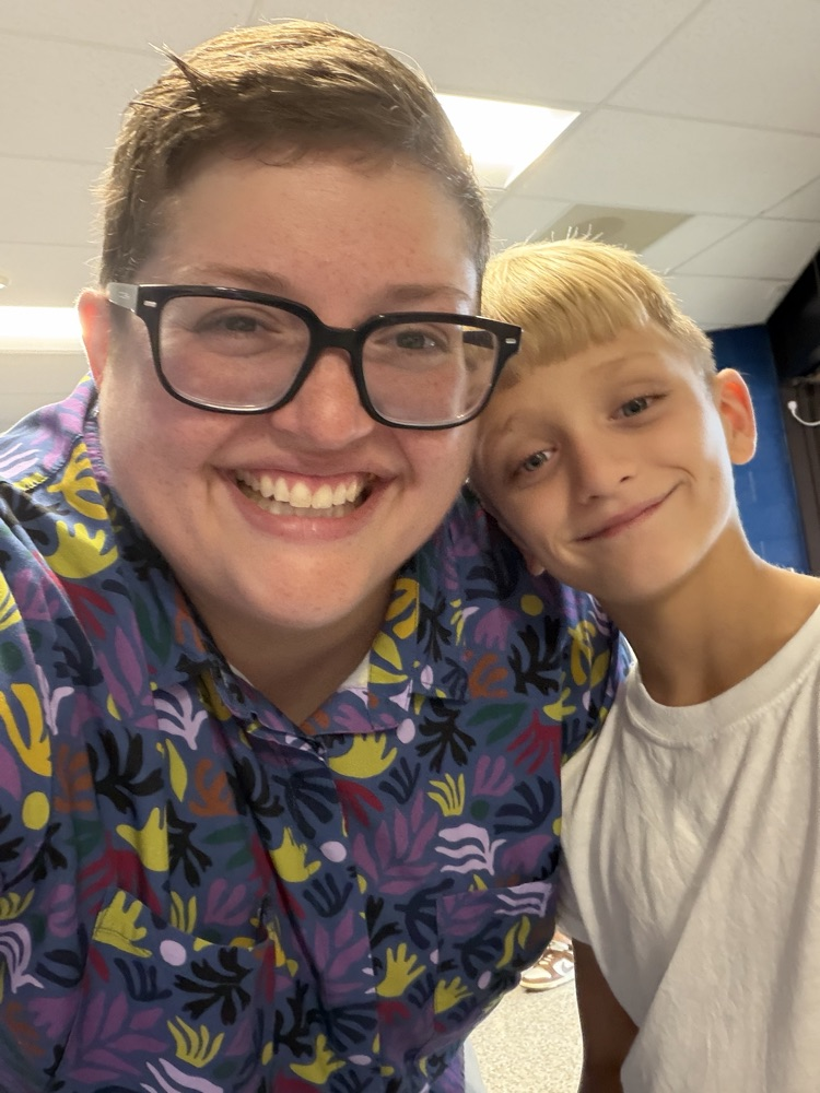 student and teacher smile for photo .