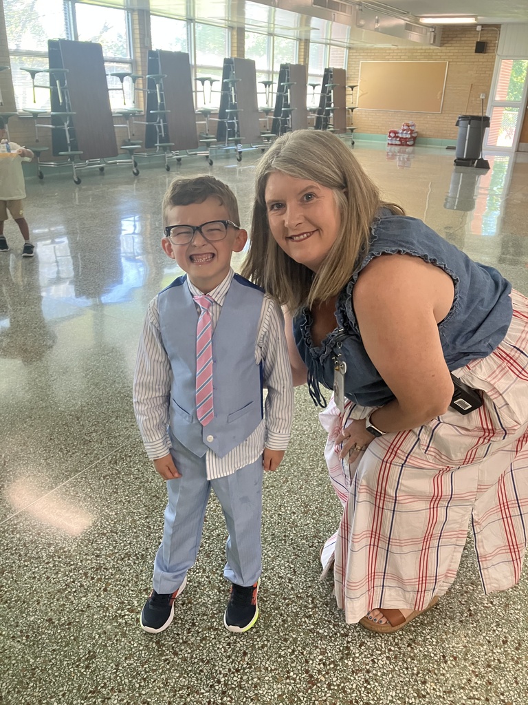 Principal Wheeler and new kindergartener stand smiling for the first day of school.