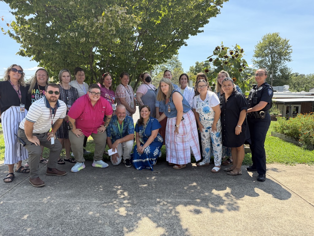 Woodfin staff stands in two rows , smiling for photograph.