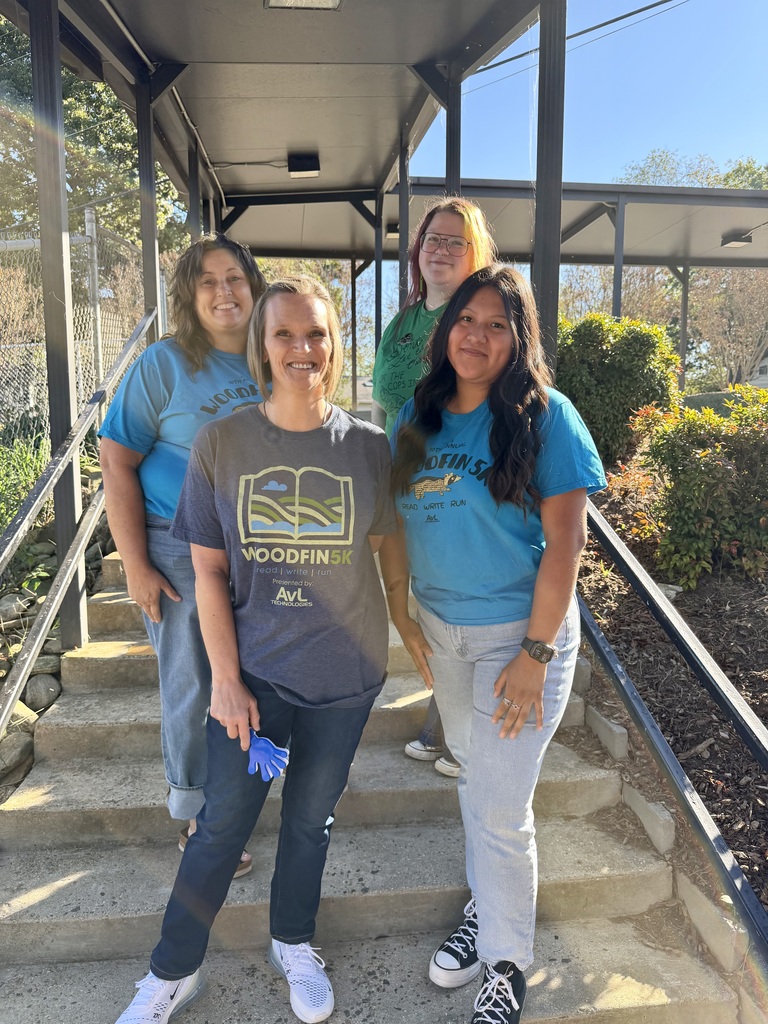 Four people stand on stairs and smile. 