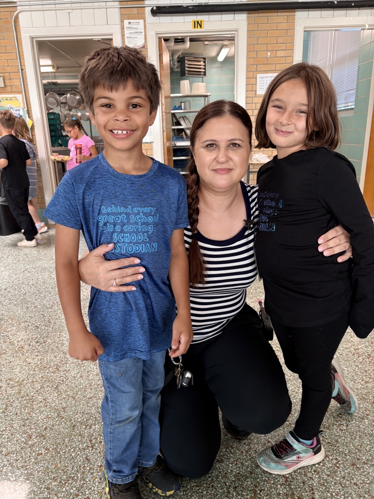 Three people standing smiling for picture.