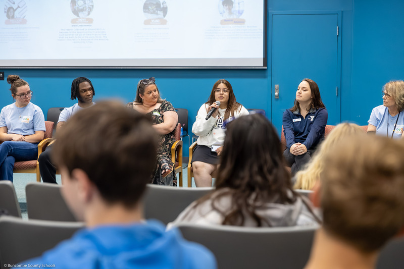 A student speaks to a crowd during a panel discussion.