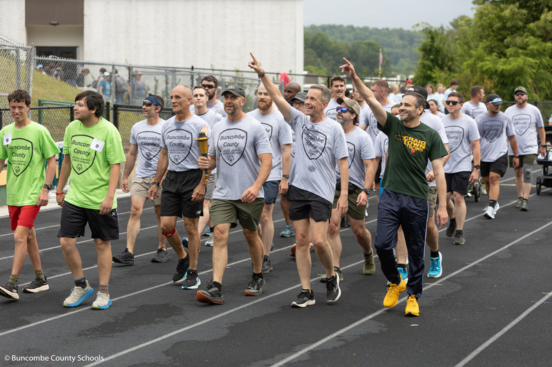 Torch run participants walking around the track. 