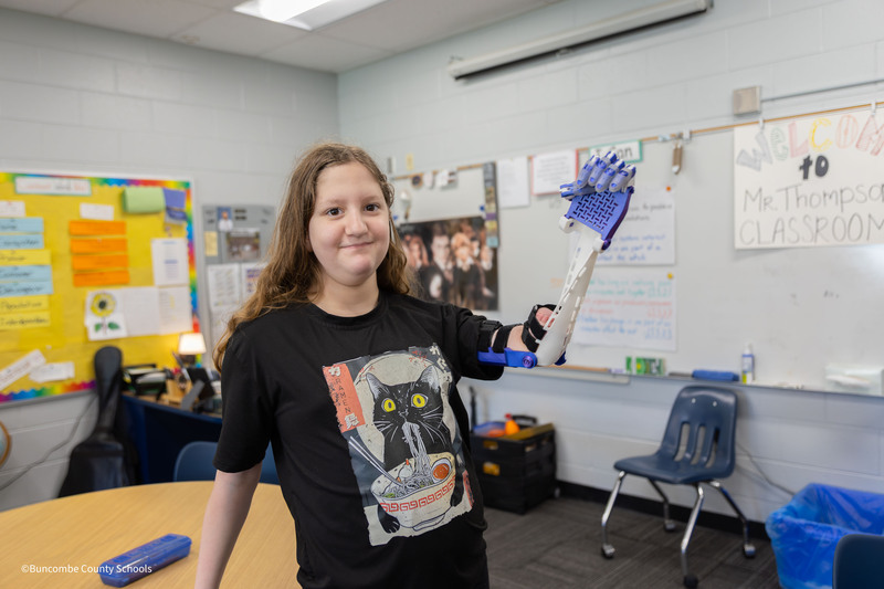 Student flexing prosethic arm