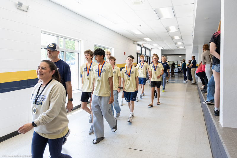 Tennis players walk down a hallway during the parade.