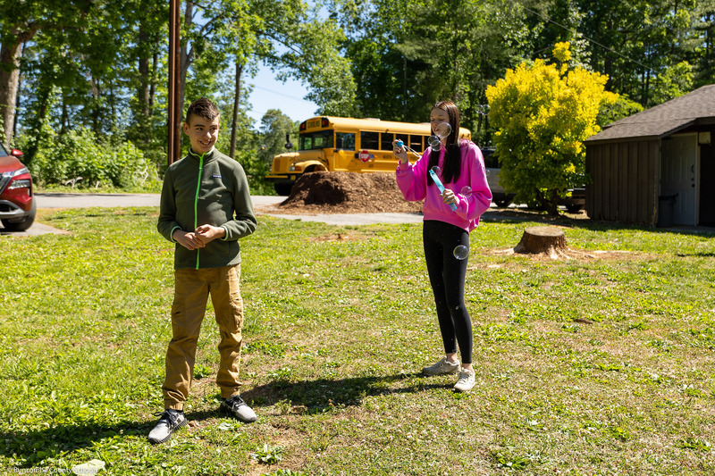 A student blows bubbles near another student.