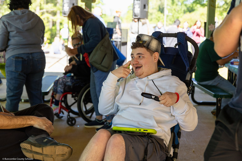 A student smiles while operating a walkie-talkie.