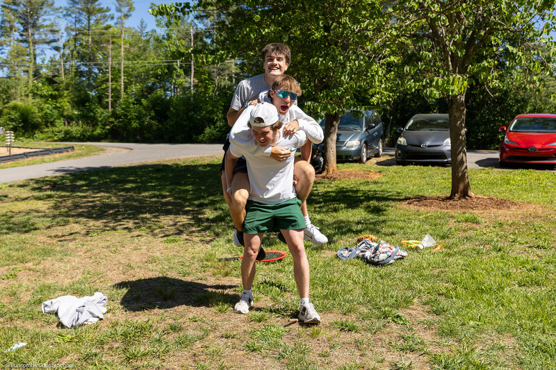 Three students pile on each other's backs.