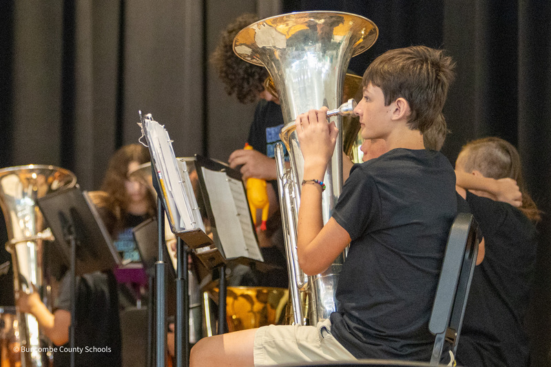 A student sits and holds his baritone.