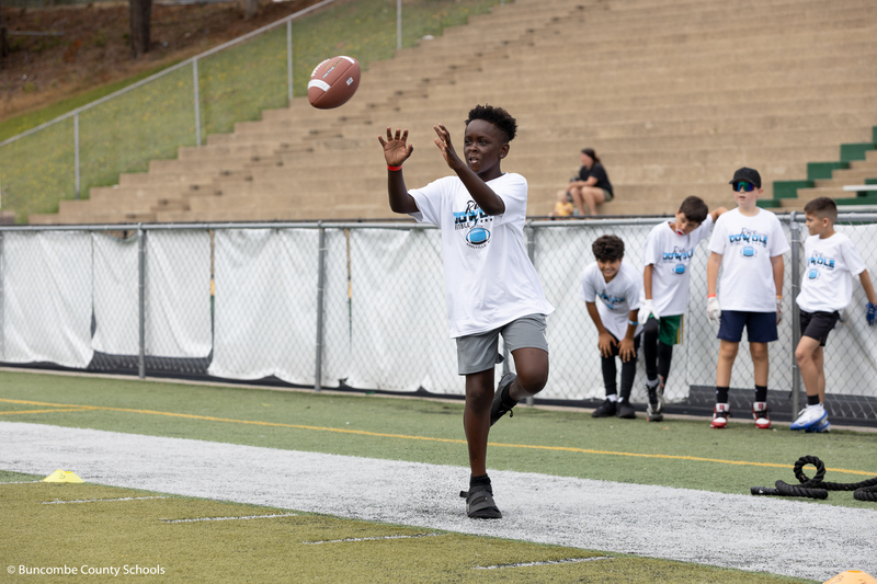 Kid catching a football. 
