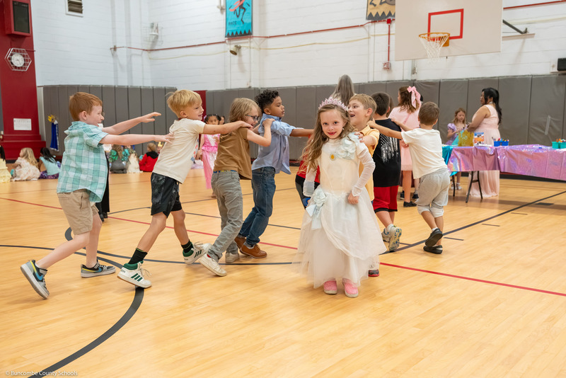 Kids form a Conga line in the gym.