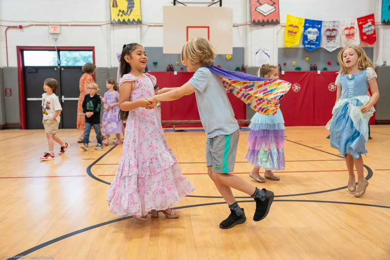 Kids dance together in the gym.
