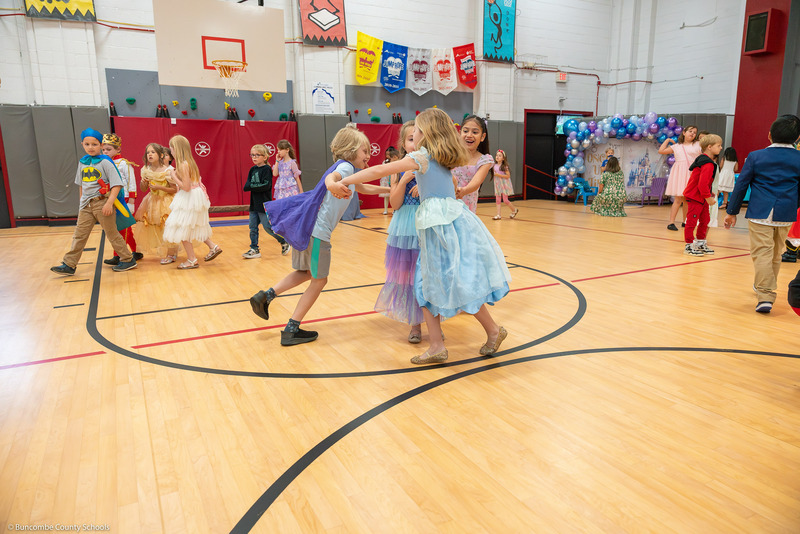 Kids dance together in the gym.