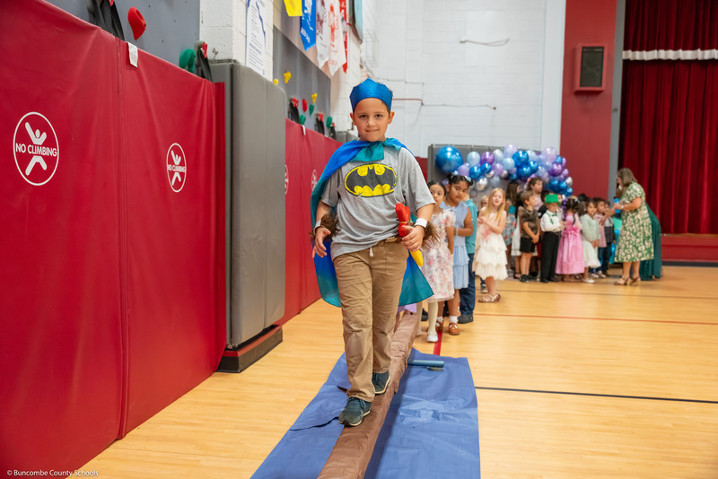 A boy walks on a balance beam.