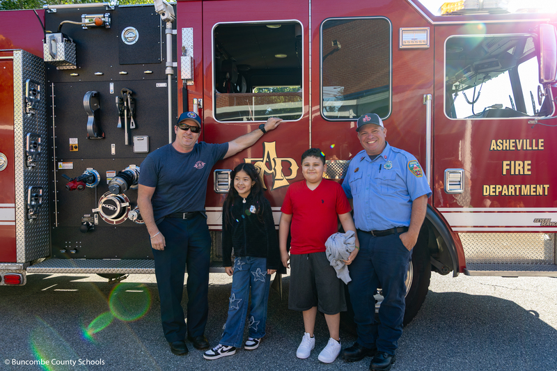 Students with the firefighters in front of the fire truck. 