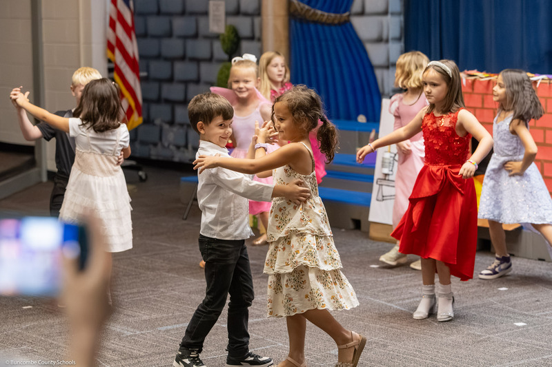 A boy and girl dance together.