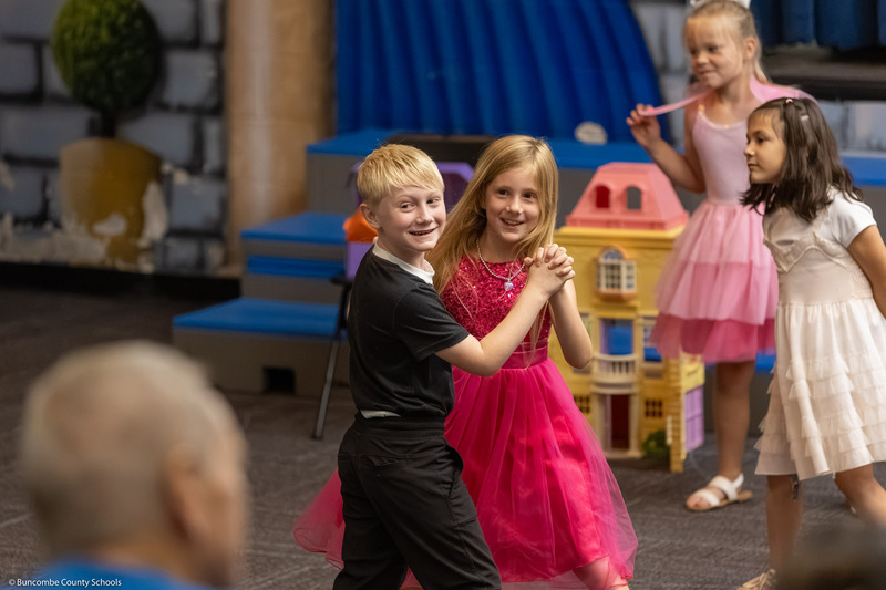 A boy and girl dance together.