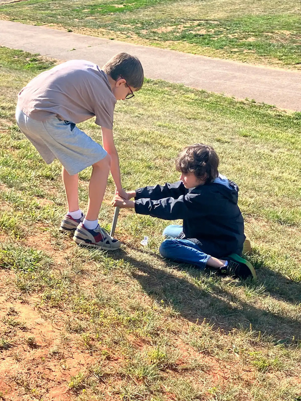 Students collecting a sample of dirt. 