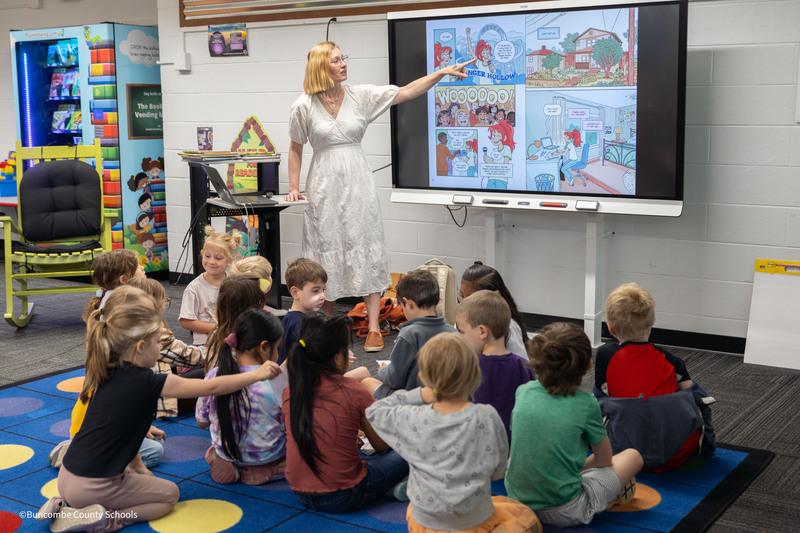 A cartoonist shows off her illustrations to students
