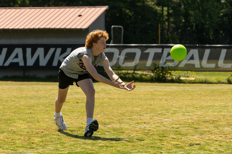 A fielder reaches out to catch a ball.