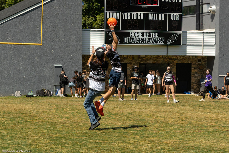 Two fielders jump for a ball.