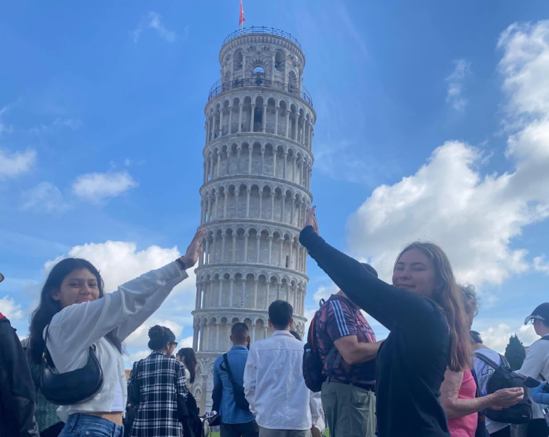 2 students pose in front of the Leaning Tower of Pisa