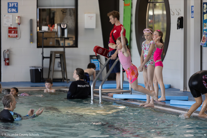 Girl jumping into the pool. 