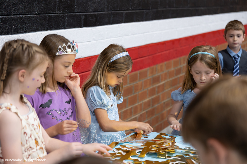 Kids making a paper crown to wear. 