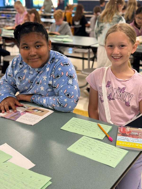 Two girls playing a reading game.