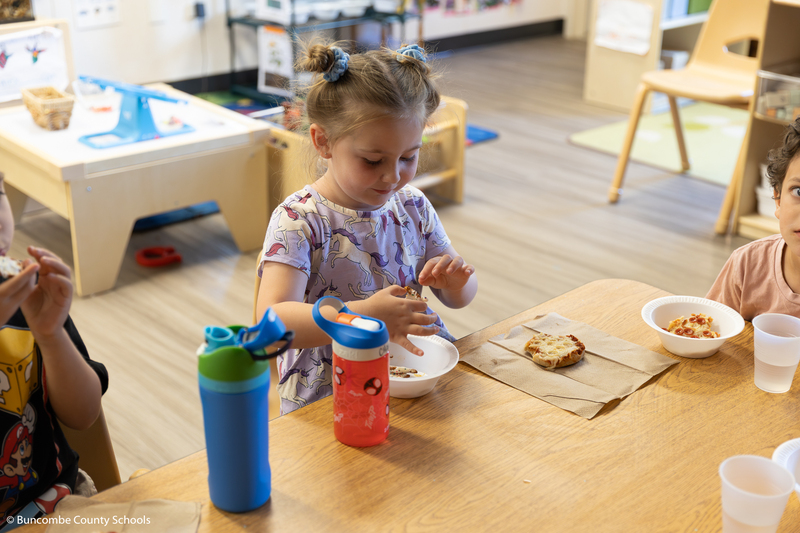 PreK student eating a snack. 